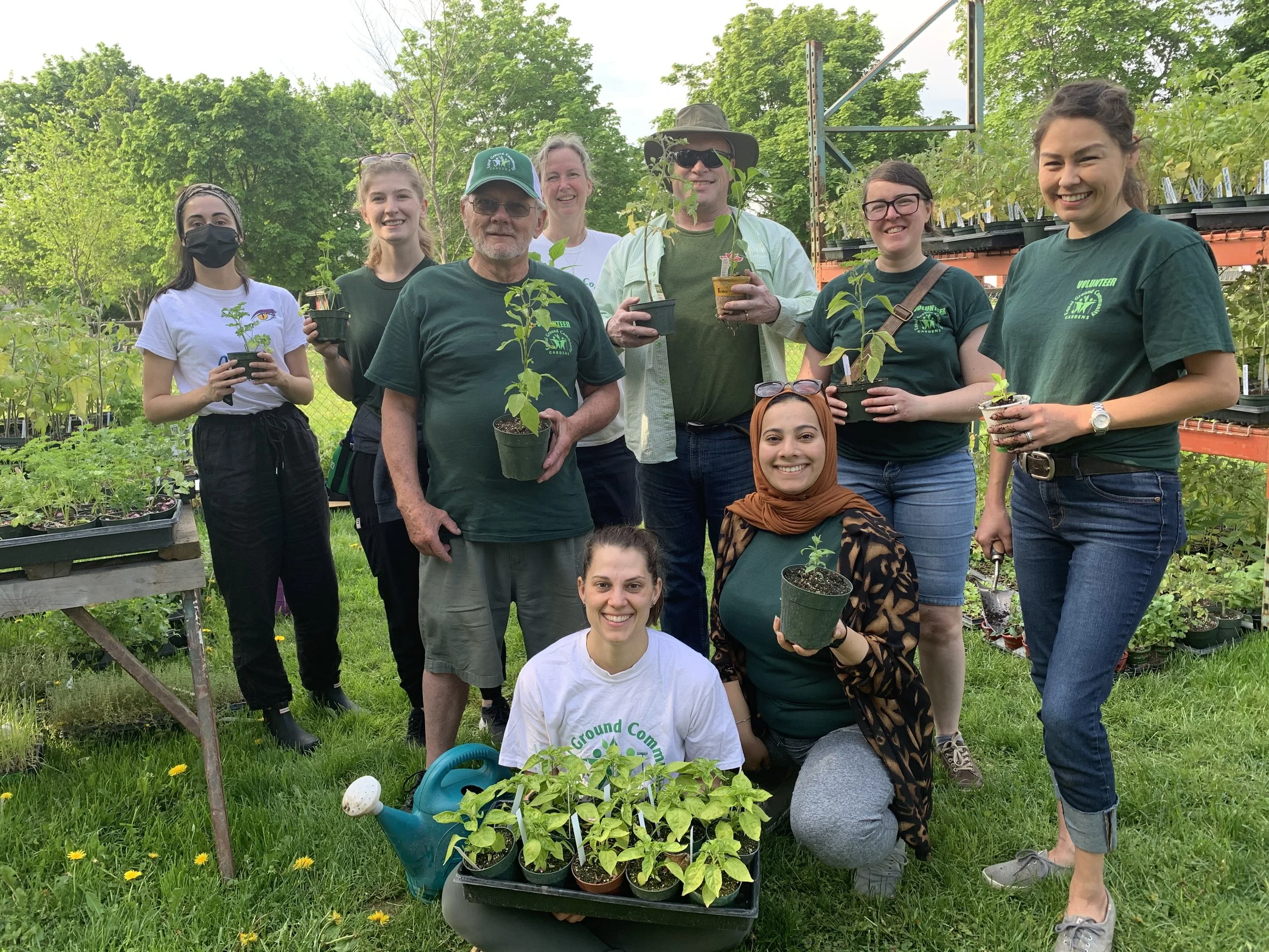 Some of our lovely volunteers smiling holding plants at the gardens