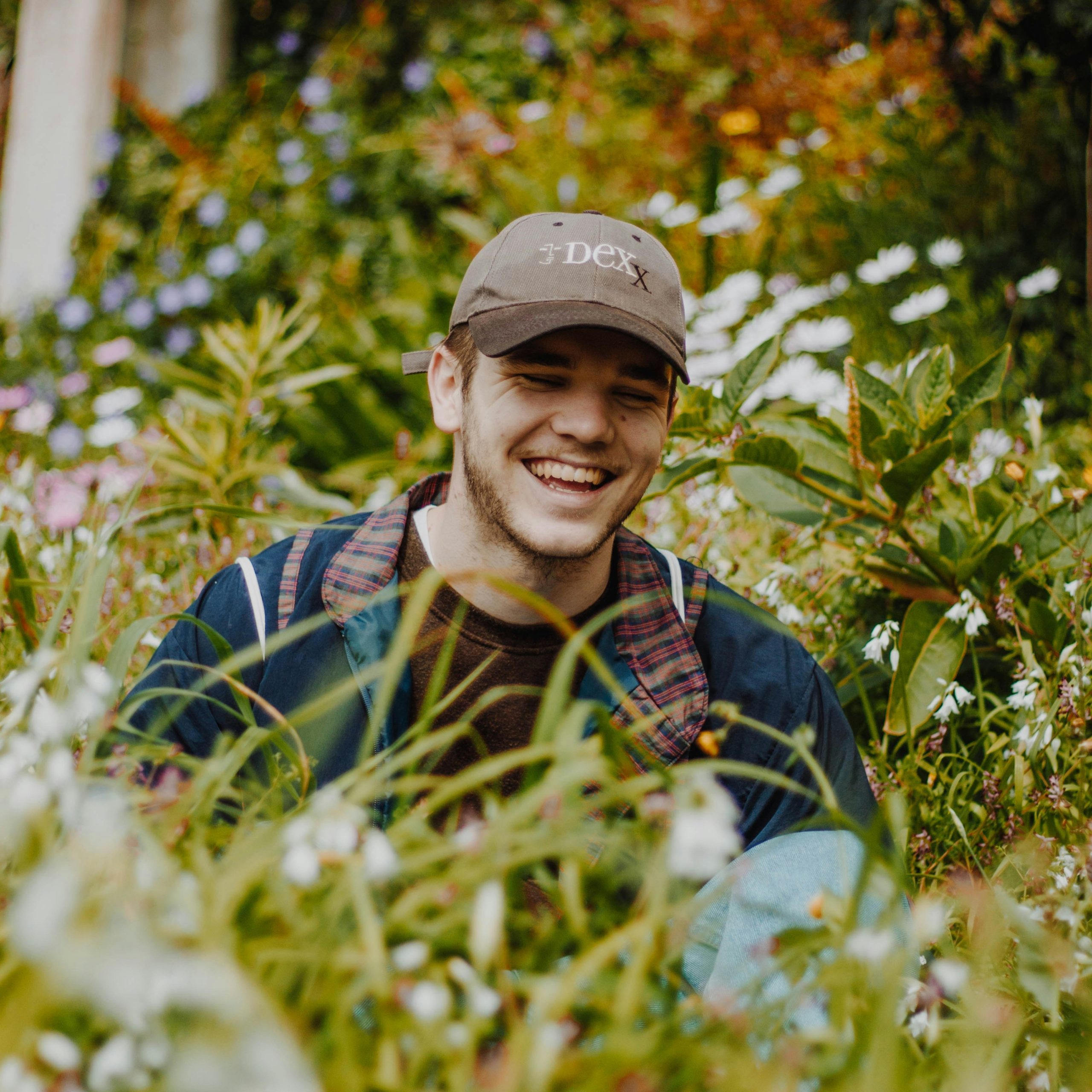 James Thompson smiling surrounded by plants in the gardens