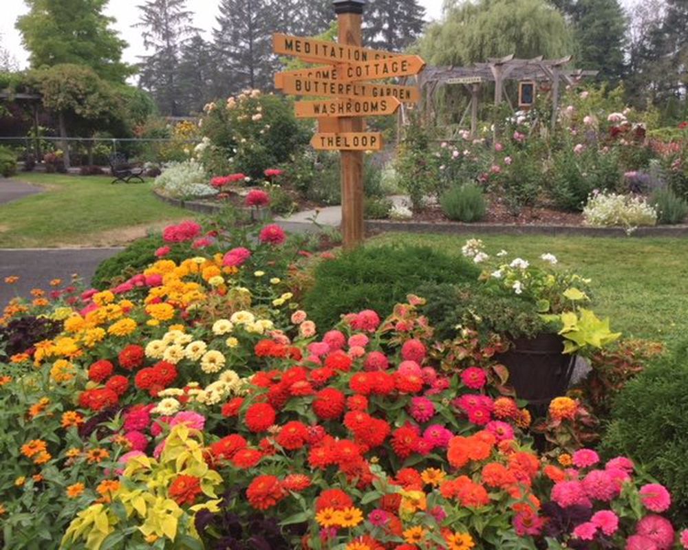 The directional signpost and flowerbed beneath it at the gardens