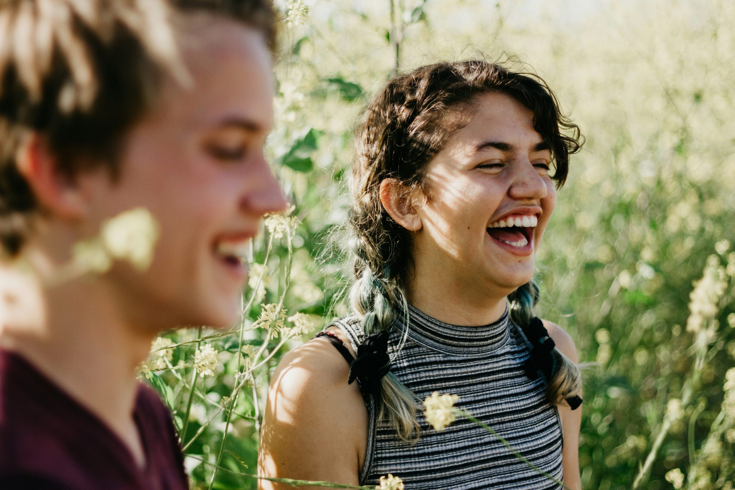Two people laughing and smiling in a garden